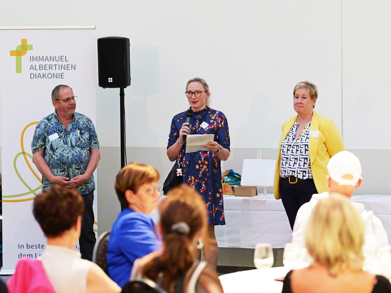 v.l.n.r. stehen die Sprecherinnen und Sprecher der Pflegefachkonferenz Thomas Fricke, Joanna Strozyk und Martina Kringe bei der Moderation des Pflegefachtags auf der Bühne v.l.n.r. stehen die Sprecherinnen und Sprecher der Pflegefachkonferenz Thomas Fricke, Joanna Strozyk und Martina Kringe bei der Moderation des Pflegefachtags auf der Bühne