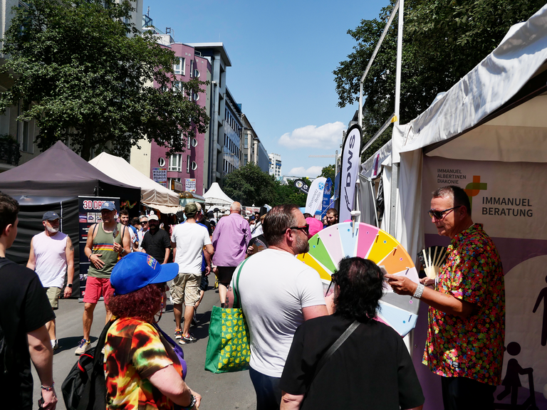 Stand mit Glücksrad und vielen Menschen