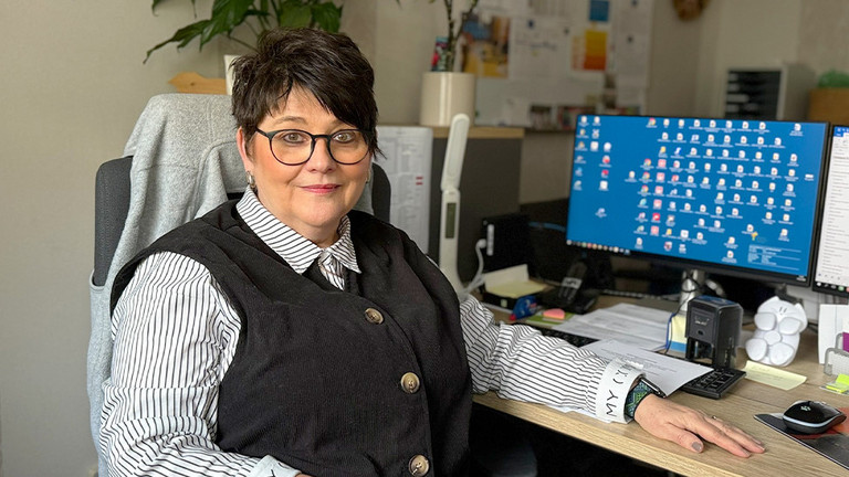 Marion Swietza, Leiterin „Besondere Wohnform“ sowie des ambulanten Bereichs beim Immanuel Suchthilfeverbund Guben, sitzt in ihrem Büro am Schreibtisch vor einem Monitor und blickt in die Kamera.