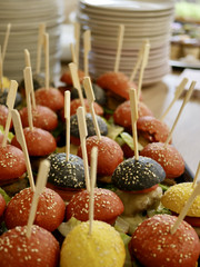 Mehrere kleine Fingerfood-Burger mit Holzspießen und farbigen Burgerbrötchen auf dem Büfett bei der Wiedereröffnung der Tagespflegestätte für ältere Menschen im Immanuel Seniorenzentrum Kläre Weist in Petershagen